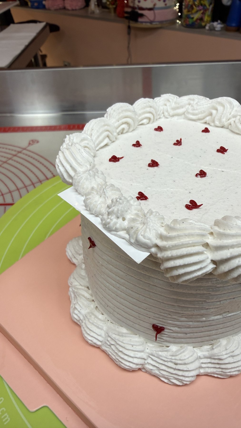 Gateau rond blanc decoré de chantilly avec petits coeurs rouges
